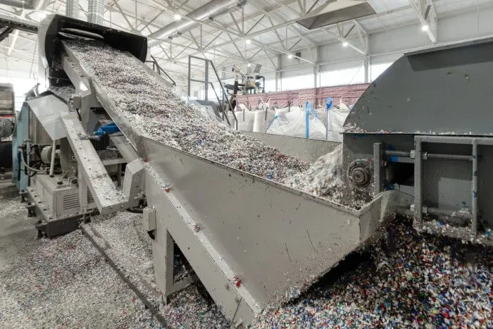Plastic shredding conveyor belt machinery inside recycling facility