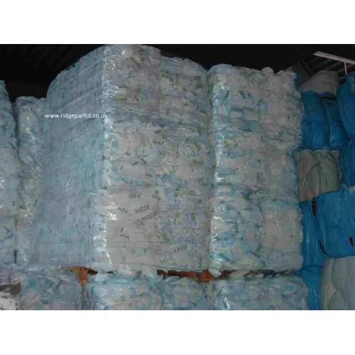 Compressed bales of used diaper scrap stacked in warehouse for recycling