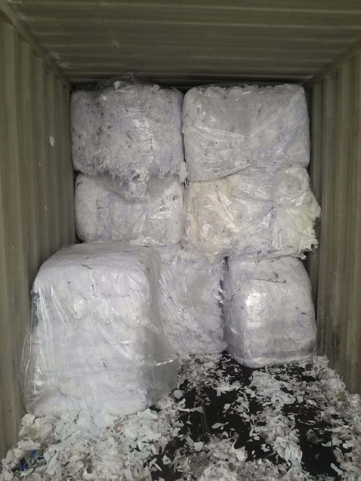 Baled white plastic film scrap packed in shipping container