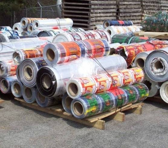 Rolls of printed plastic film and laminated packaging scrap on pallets