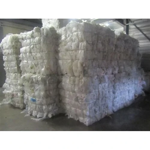Large stacked bales of white plastic film scrap in warehouse