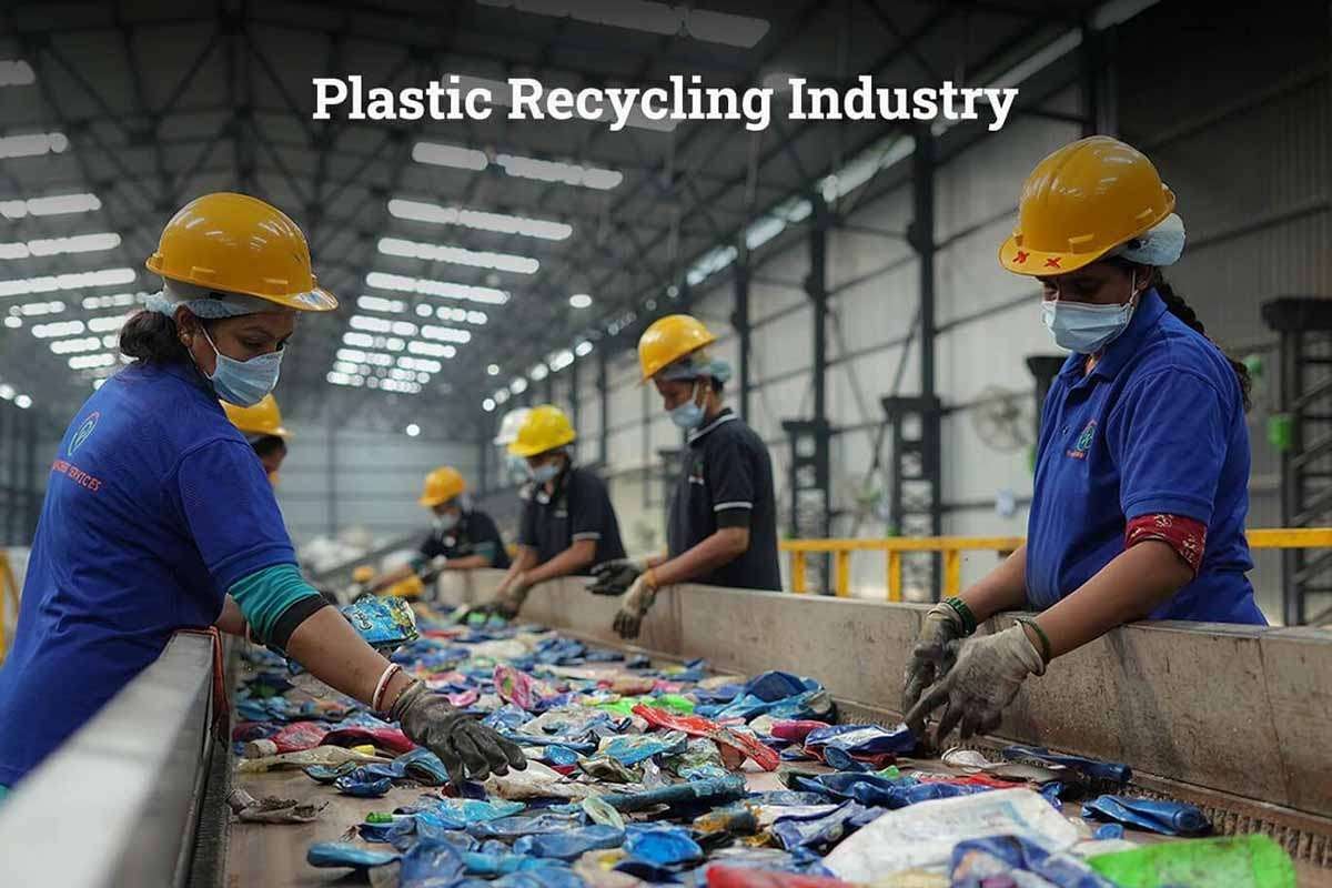 Workers in plastic recycling industry sorting materials on conveyor